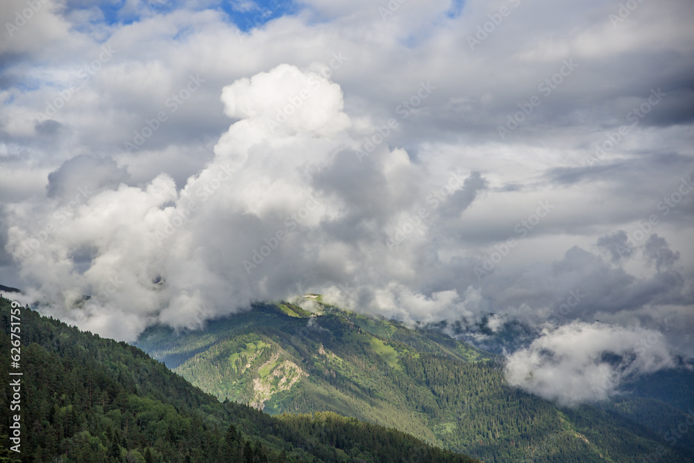 Soft focus. Clouds float over a mountain valley.