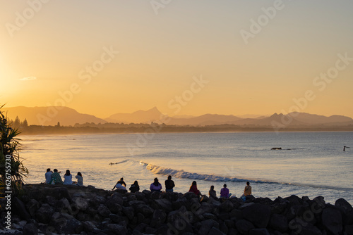 Tourists enjoy the sunset looking towards Belongil Beach, New South Wales, Australia photo