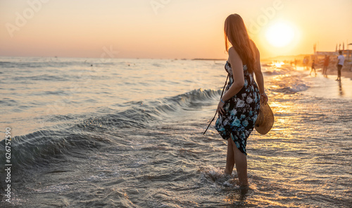 Happy young Woman in a hat and short dress enjoys sunset at sea © weyo