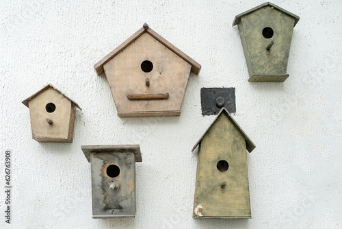 wooden birdhouse on white wall