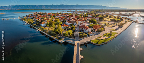 Nin, Croatia - Aerial panoramic view of the historic town and small island of Nin with traditional salt still fields and blue Adriatic sea on a sunny summer morning in Dalmatia region of Croatia photo