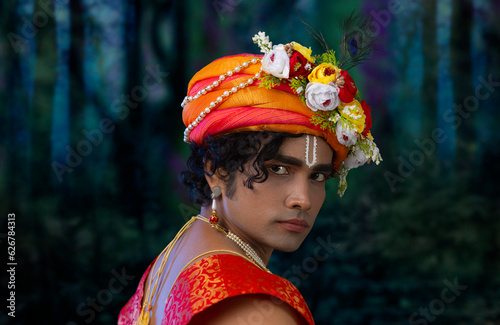 Close-up portrait of young man dressed up as Lord Krishna on the occasion of Janmashtami photo