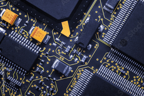 Closeup of Printed Circuit Board with processor, integrated circuits and many other surface mounted passive electrical components.