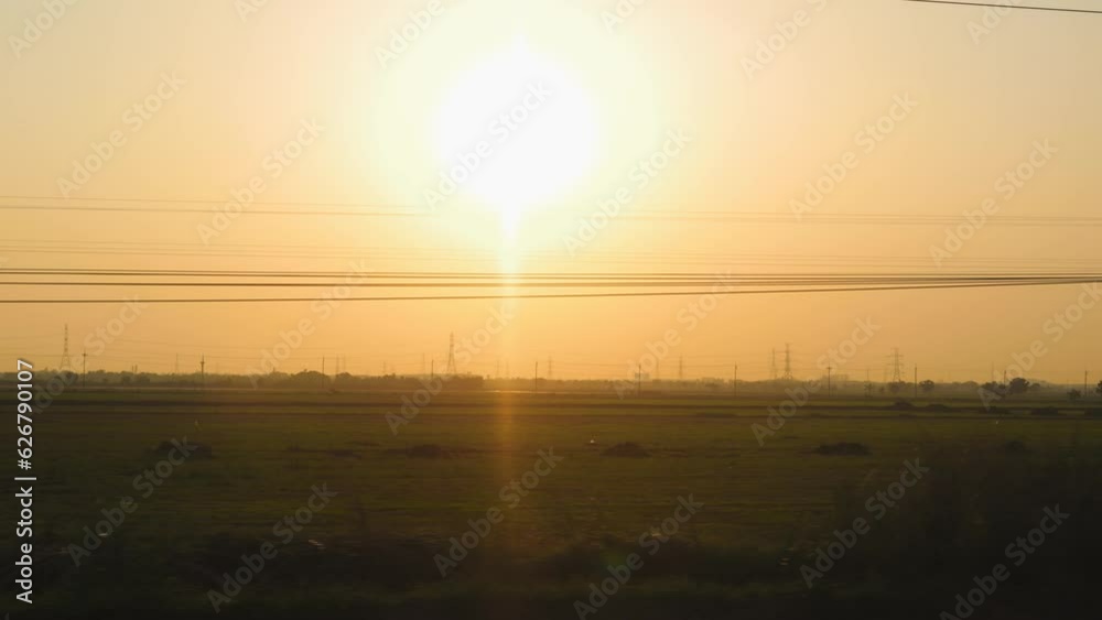 View from window of moving train on rice fields during beautiful summer sunset, High Quality 4K Cinematic Travel Concept Footage. Thailand. View from window of moving train on rice fields during beautiful summer sunset, High Quality 4K Cinematic Travel Concept Footage. Thailand.