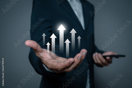 Businessman hand holding growth rising arrow up showing growing revenue and benefits. Successful plan or strategy, excellent sale or investment performance.