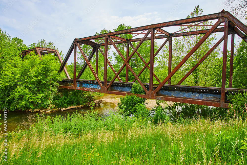 Summer shot of Kokosing River with train bridge and grasses Summer shot of Kokosing River with train bridge and grasses