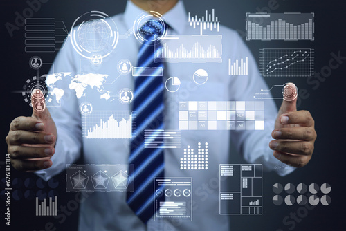 Data analyzer or data scientist is compiling data in various ways to analyze, summarize and report the results. various type of graphs float in the foreground as virtual screen digital transformation