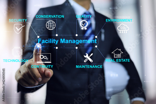 Businessman or engineering manager with white helmet pointing to a facility management wording. Real estate maintenance management concept. photo