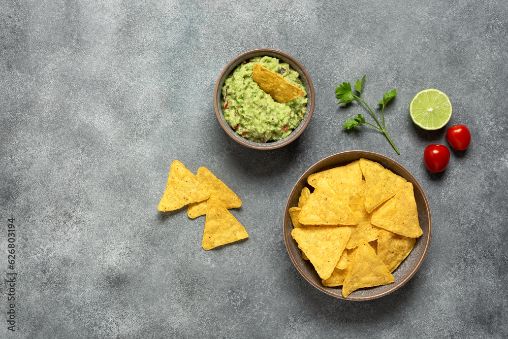 Guacamole with nachos on a gray background. Mexican food. Top view, flat lay, copy space. Guacamole with nachos on a gray background. Mexican food. Top view, flat lay, copy space.