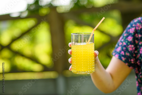 Dziewczyna trzymająca szklankę zimnego soku pomarańczowego 