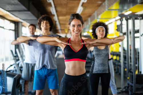 Fitness, sport, people and lifestyle concept. Group of smiling people exercising together in gym