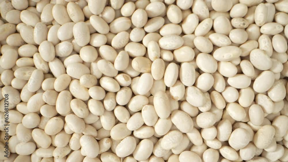 In a mesmerizing macro video, white kidney beans shine with plump texture, creamy color, and intricate details, unveiling their captivating natural beauty up close. White kidney beans background
