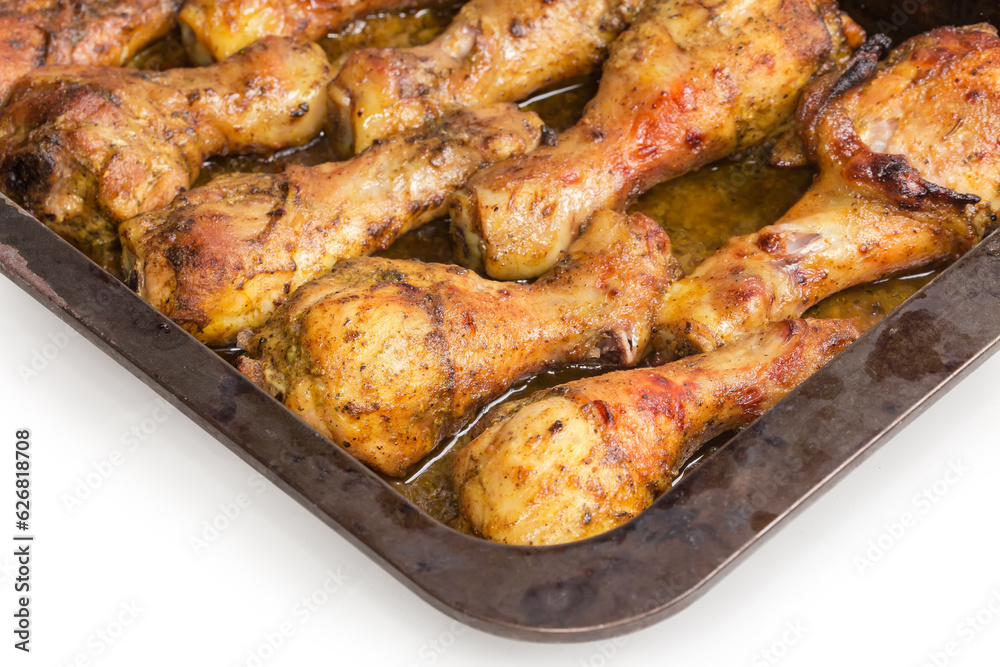 Baked chicken legs on metal oven-tray, fragment close-up Baked chicken legs on metal oven-tray, fragment close-up