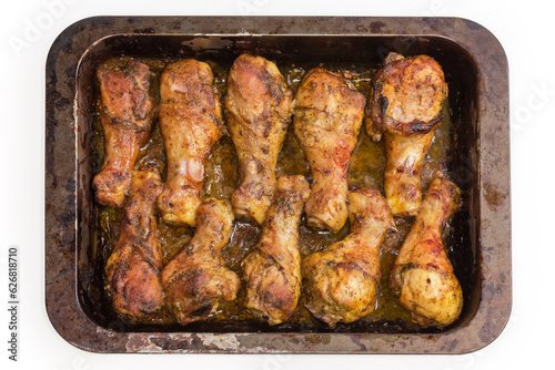 Baked chicken legs on metal oven-tray, top view