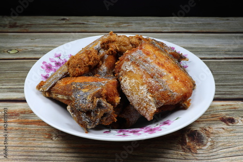 Pile of deep fried Cutlass fish (Largehead Hairtail) serving on the plate. Famous crispy and crunchy seafood menu in Asia restaurant.