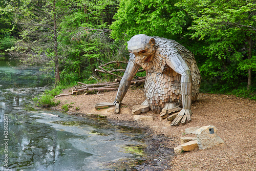 Obraz na plátně Friendly giant Little Nis staring at dirty pond water while sitting near trees_