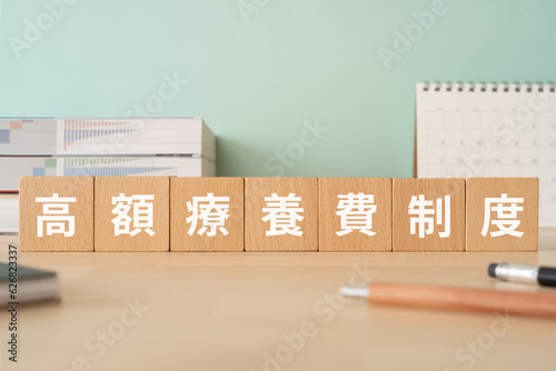 高額療養費制度と書かれたブロックが置かれたデスク