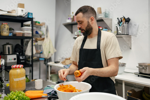 Young chef peeling carrots © Imanol