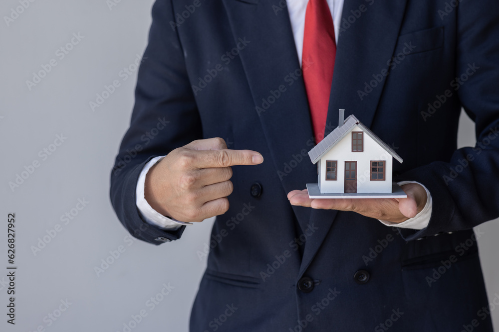 Mortgage concept. Small toy house in business man hand buy or sell real estate Financial agent complete Home sales and home insurance concept, Mortgage concept. Small toy house in business man hand buy or sell real estate Financial agent complete Home sales and home insurance concept,