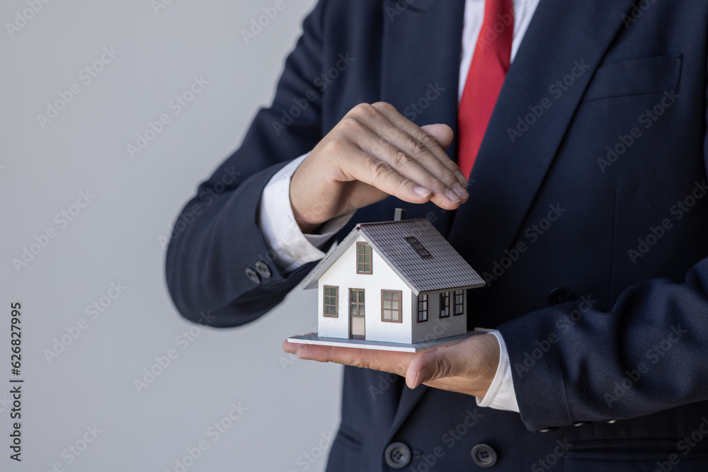 Mortgage concept. Small toy house in business man hand buy or sell real estate Financial agent complete Home sales and home insurance concept, Mortgage concept. Small toy house in business man hand buy or sell real estate Financial agent complete Home sales and home insurance concept,