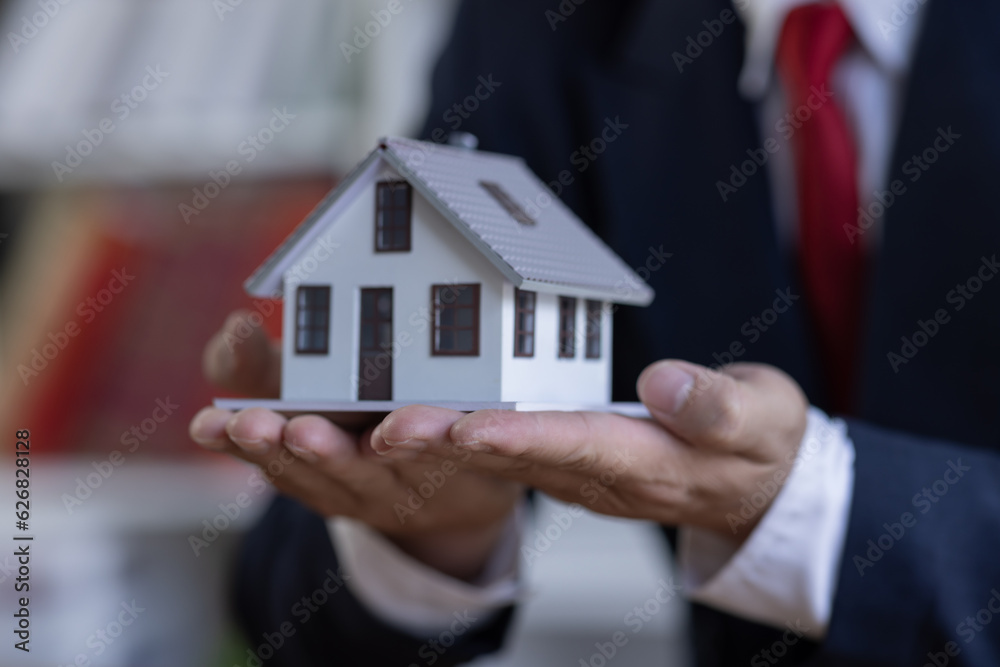 Mortgage concept. Small toy house in business man hand buy or sell real estate Financial agent complete Home sales and home insurance concept, Mortgage concept. Small toy house in business man hand buy or sell real estate Financial agent complete Home sales and home insurance concept,
