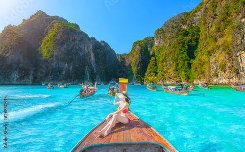 Traveler woman joy fun relaxing on boat at Pileh Lagoon Bay, Phi Phi Island, Krabi, Tourist girl on summer holiday vacation trip, beautiful place, crystal clear emerald waters. photo
