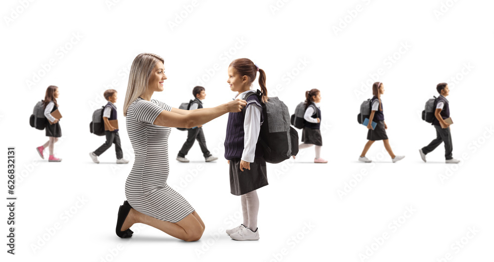 Mother helping daughter getting ready for school and other children walking in the back Mother helping daughter getting ready for school and other children walking in the back