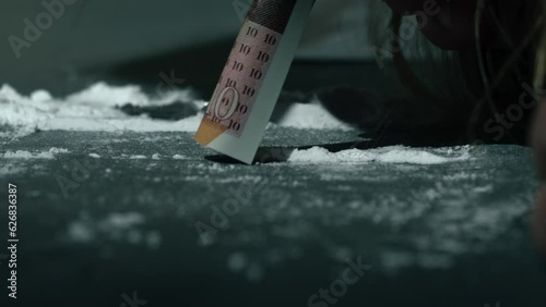 Drug addict snorting line of cocaine