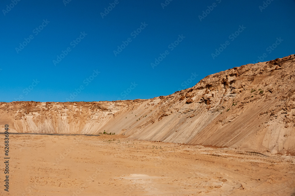 sand pit against the blue sky, forest in the background