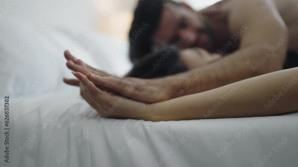 Romantic sexy moments lifestyle for a young couple at home, hot Asian lady wearing black bra teasing young aroused man on bed, passionate couple enjoying sensual foreplay petting before making love