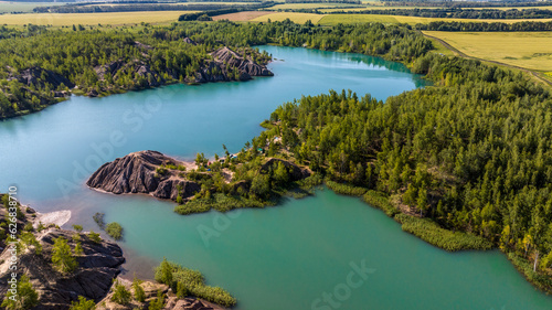panoramic view of the high hills of the lake with turquoise water and green forest from the reserve in the Tula region taken from a drone