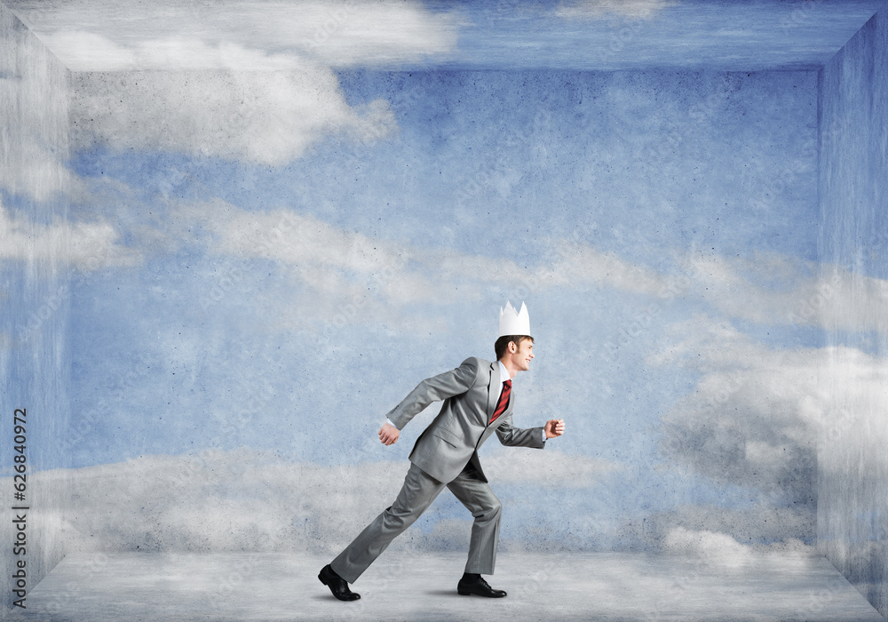King businessman in elegant suit running in empty room with blue sky on wall King businessman in elegant suit running in empty room with blue sky on wall