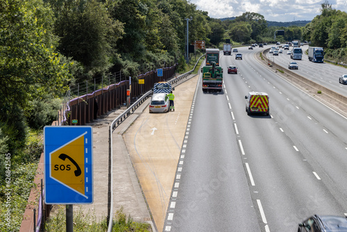 Car rescue worker stands close to traffic in refuge on smart motorway © Harry Green