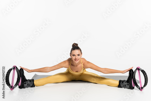 flexible woman exercising on fitness mat while wearing kangoo jumping shoes, motivation, warm up