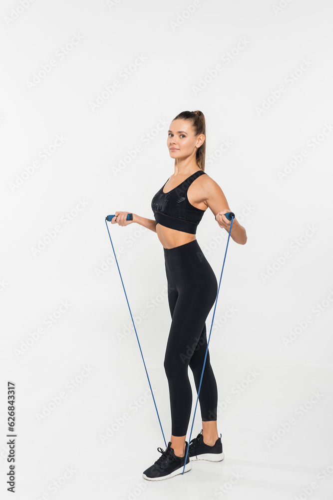 fit woman in fitness clothes holding jump rope on white background, healthy and fit concept fit woman in fitness clothes holding jump rope on white background, healthy and fit concept