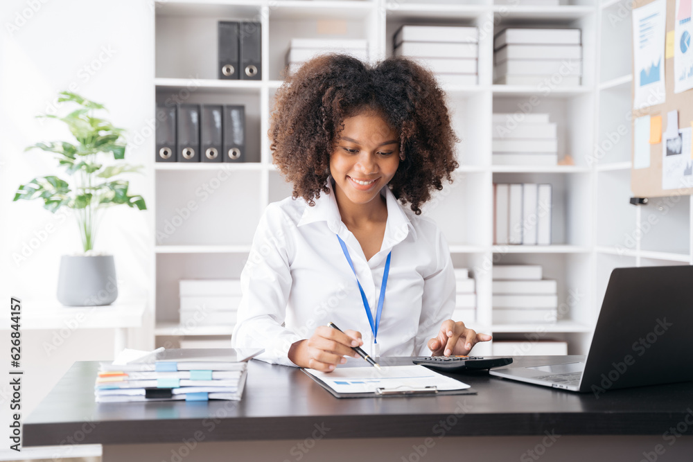 Female businessman working with holding a pen and using a calculator to calculate the numbers of static at home office. Finance accounting concept. Female businessman working with holding a pen and using a calculator to calculate the numbers of static at home office. Finance accounting concept.