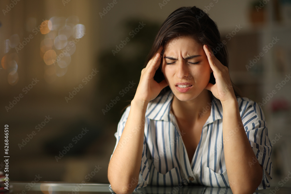 Woman suffering migraine in the night at home Woman suffering migraine in the night at home