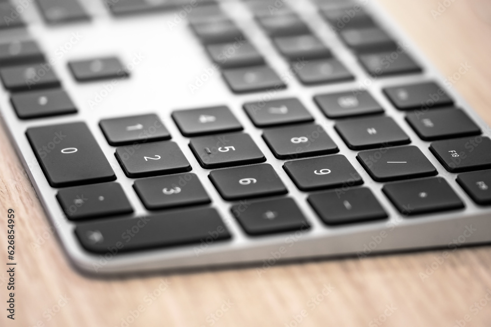 Wireless aluminum keyboard, on wooden desk, focus on button. Wireless aluminum keyboard, on wooden desk, focus on button.