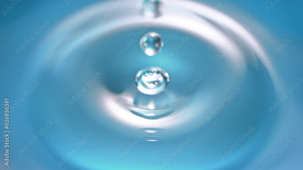 Super Slow Motion Detail Shot of Droplet Falling into Still Water Surface at 1000fps.