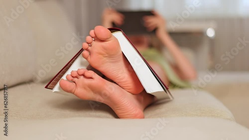 Book on feet. The schoolgirl uses a tablet instead of a book. photo