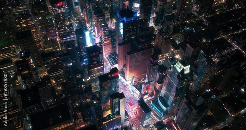 Helicopter Night Tour of New York City Architecture. Fly-By Over Glowing Times Square with Colorful Advertising Billboards and Groups of Tourists Enjoying Manhattan Nightlife and Admiring the Landmark