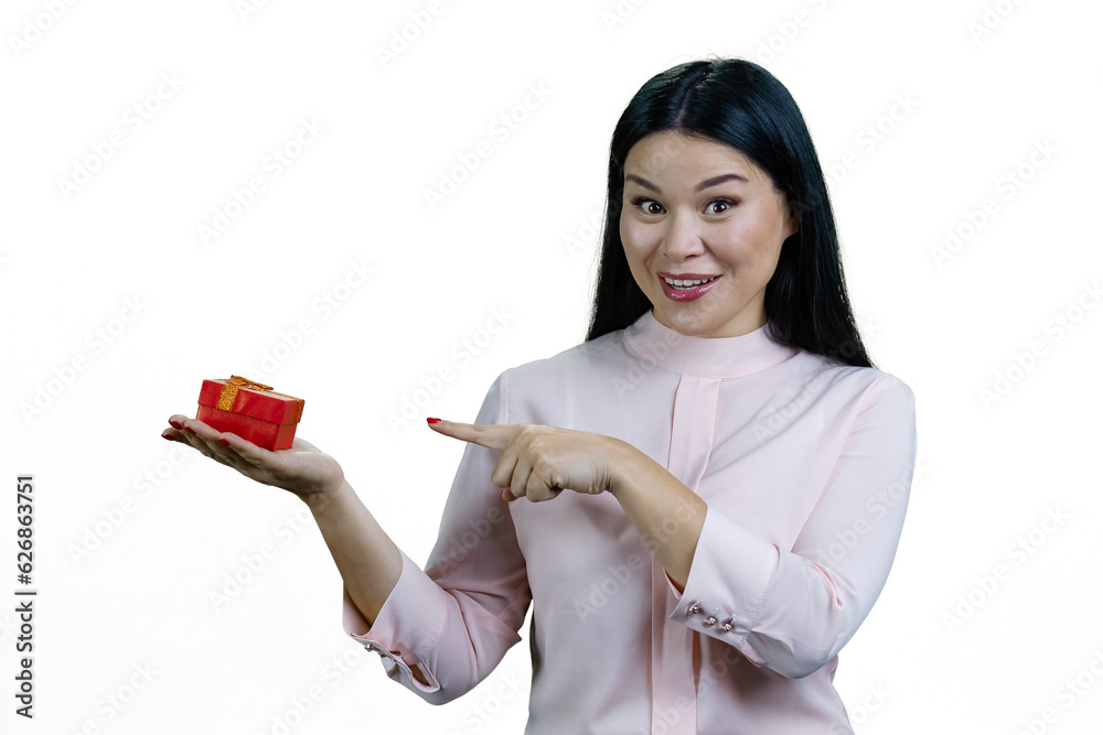Cheerful young asian woman is pointing at red gift box on her hand. Isolated on white background. Cheerful young asian woman is pointing at red gift box on her hand. Isolated on white background.