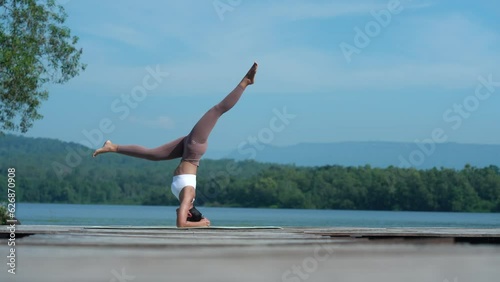 Beautiful attractive Asian woman practice fitness yoga pose on the pool above the Mountain peak in front of nature lake views, Feel so comfortable lifestyle and relax exercise in holiday morning