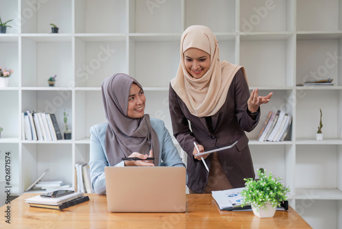 Muslim business woman wearing hijab, Beautiful muslim business lady in hijab sitting together. Business concept. Discussion, analysis of finances in the company