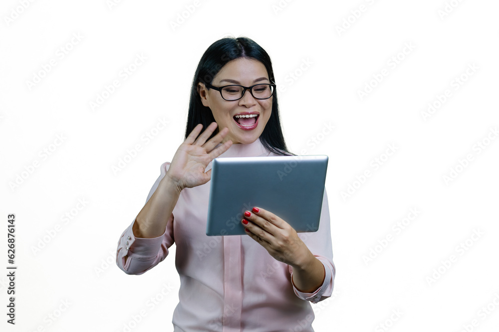 Young asian businesswoman is holding a tablet computer and waving her hand. Saying hi to someone online via video conversation. Isolated on white background. Young asian businesswoman is holding a tablet computer and waving her hand. Saying hi to someone online via video conversation. Isolated on white background.