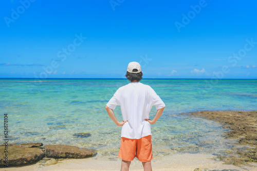 南国の美しいビーチを眺める男性