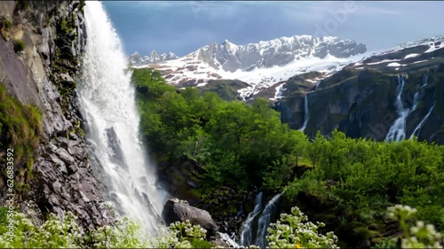 waterfall in the mountains, beautiful waterfalls and mountain sonwy peaks in the background  photo