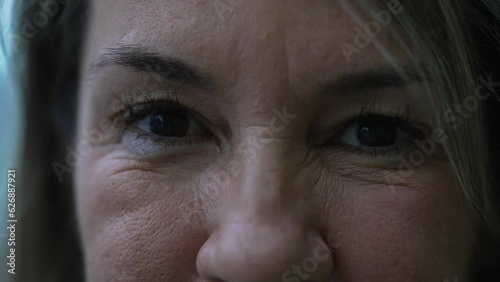 Extreme macro close-up of a woman in her 50s looking at camera with stern serious expression