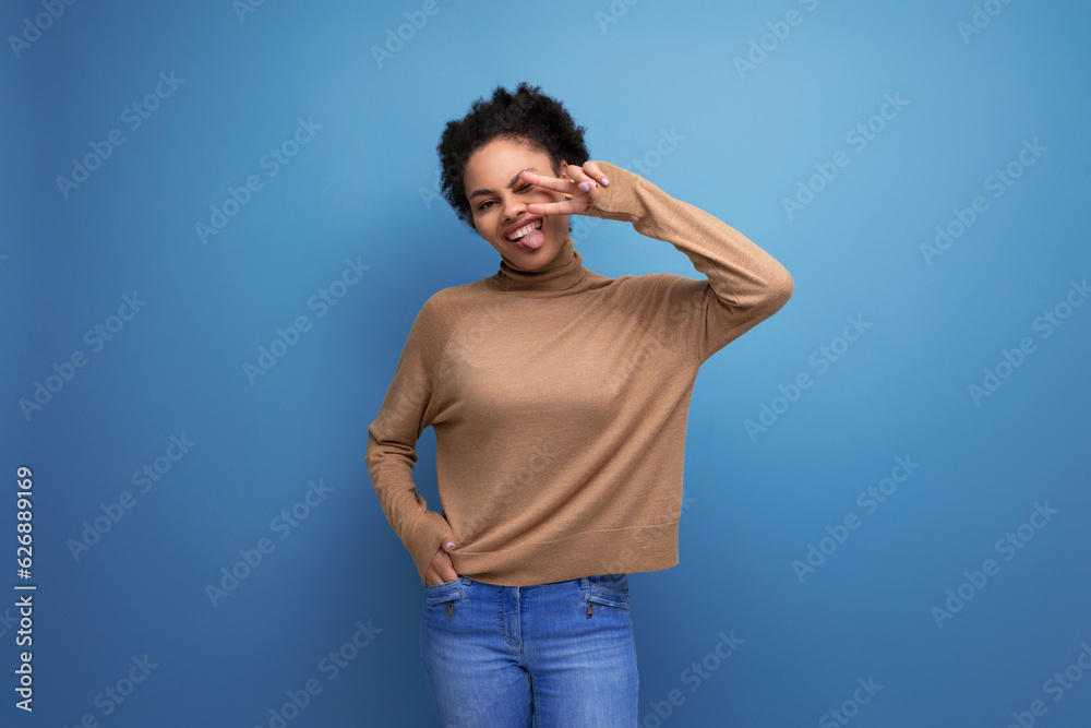young authentic hispanic lady with afro curly hair in casual clothes posing against background with copy space young authentic hispanic lady with afro curly hair in casual clothes posing against background with copy space