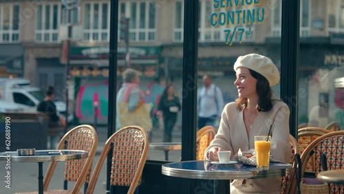 Attractive girl drinking coffee at a table in an outdoor cafe